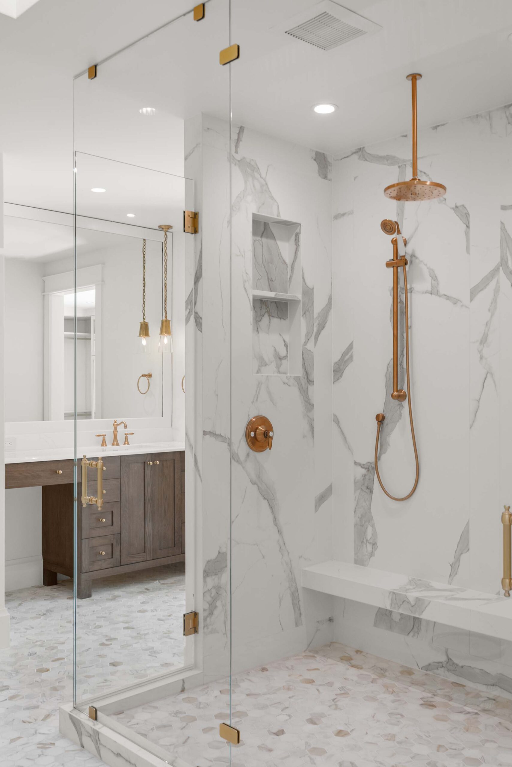 Large format marble-look tile shower with frameless glass enclosure