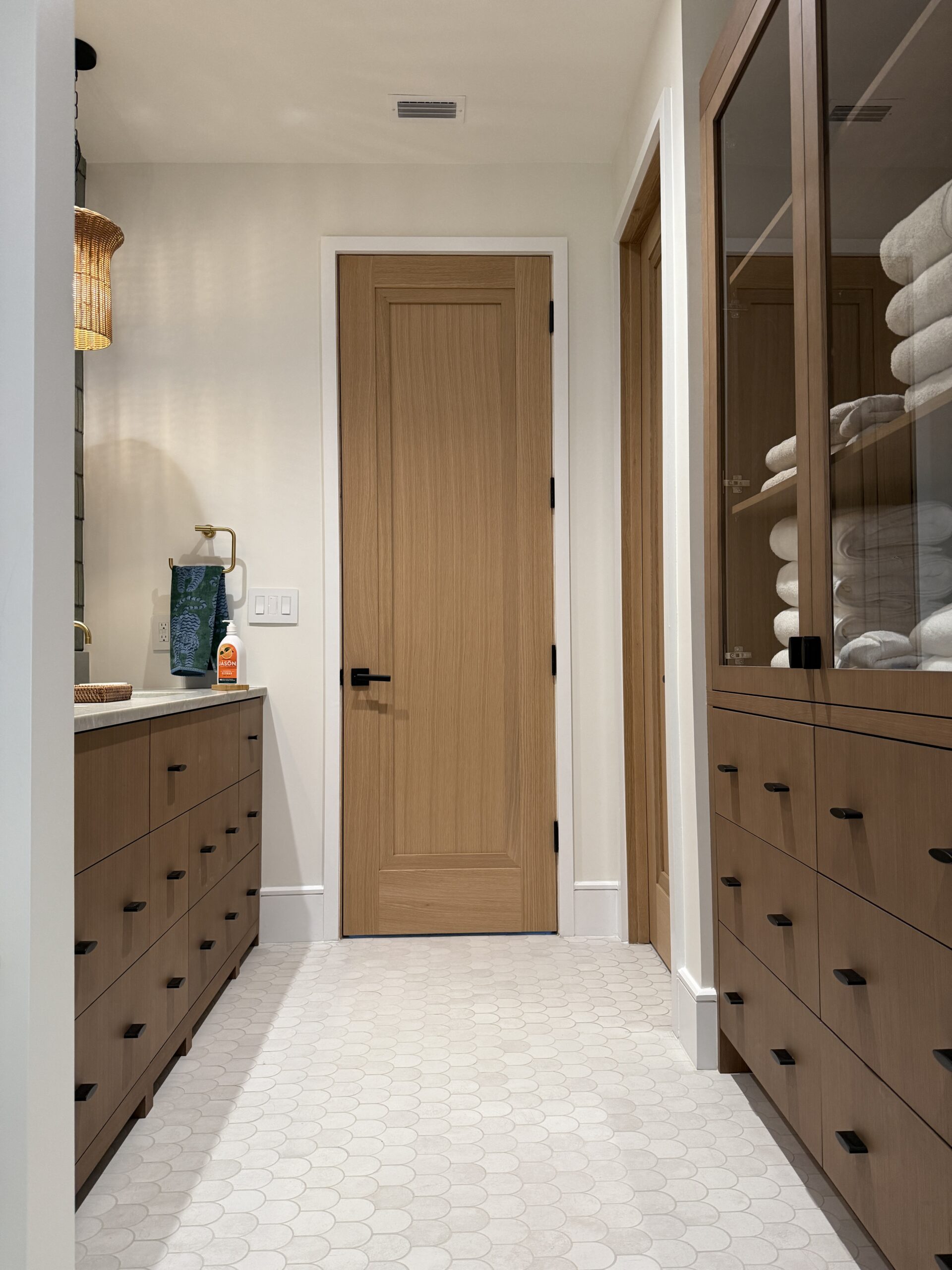 Bathroom remodel with warm cabinetry and tile flooring detail